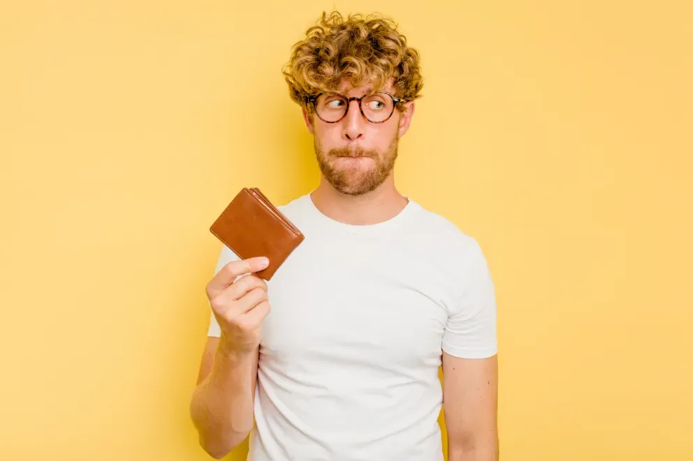 concerned man holding up wallet concerned man holding up wallet