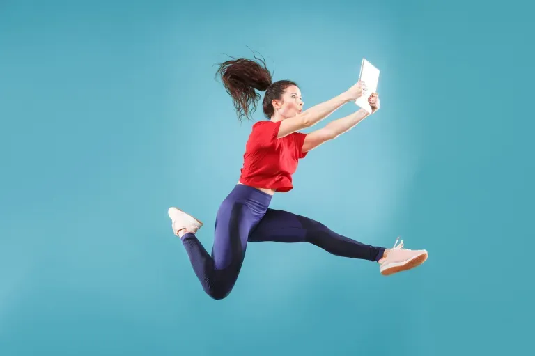 Excited woman jumping with tablet Excited woman jumping with tablet
