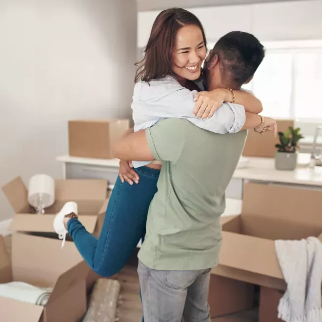 excited couple hugging in new home excited couple hugging in new home
