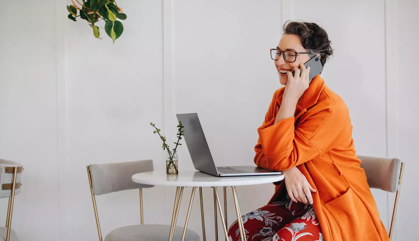 Woman looking at laptop and using the phone Woman looking at laptop and using the phone