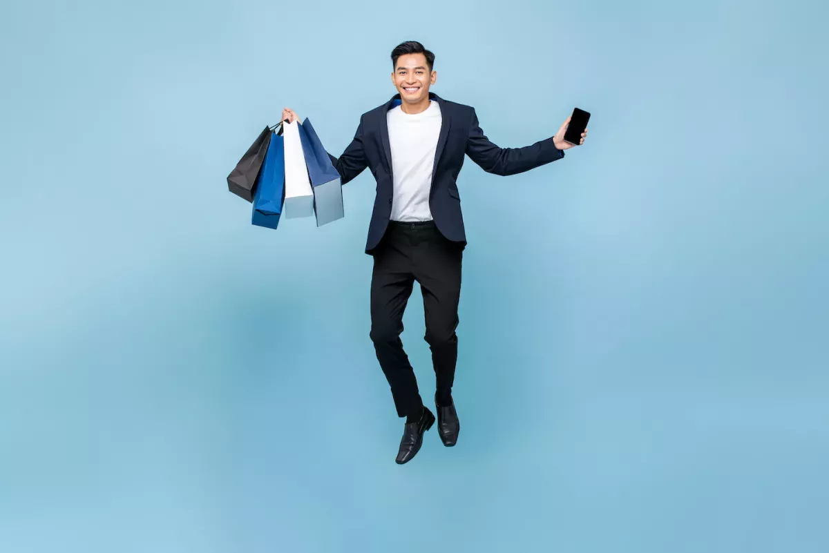 Man jumping with shopping bags and a phone Man jumping with shopping bags and a phone