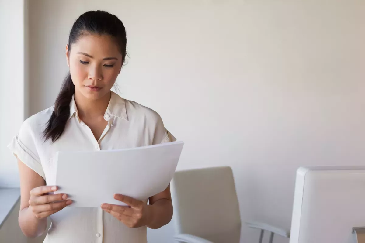 Woman in an office reading papers Woman in an office reading papers