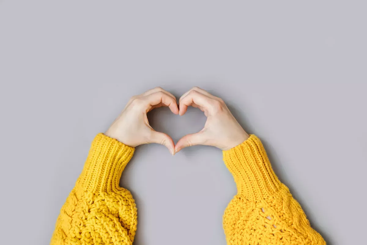 Person making the shape of a heart with their hands Person making the shape of a heart with their hands
