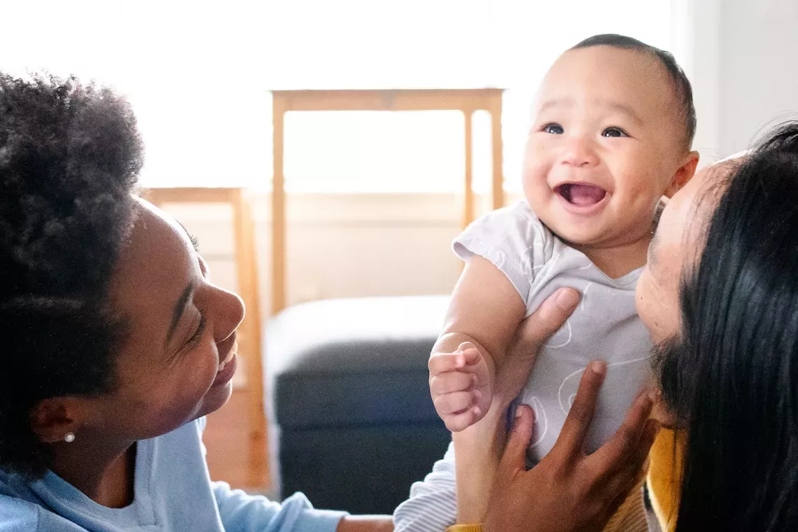 family holding newborn baby and smiling family holding newborn baby and smiling