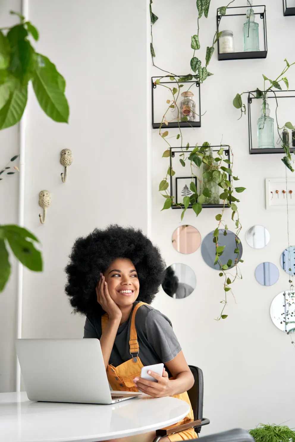 smiling young woman using laptop and cell phone smiling young woman using laptop and cell phone