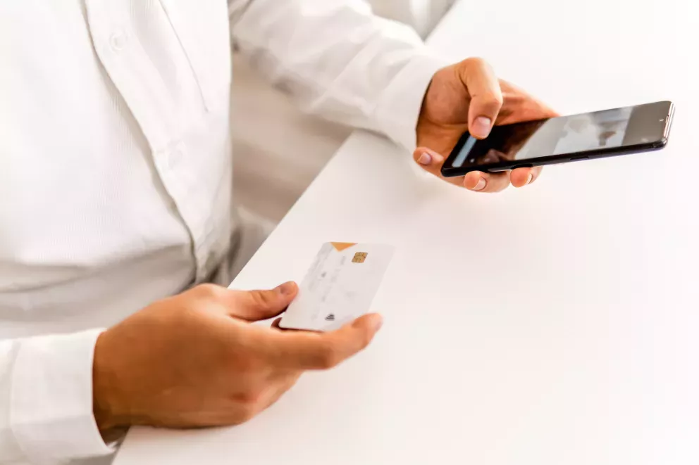 close up of person shopping on cell phone with credit card close up of person shopping on cell phone with credit card