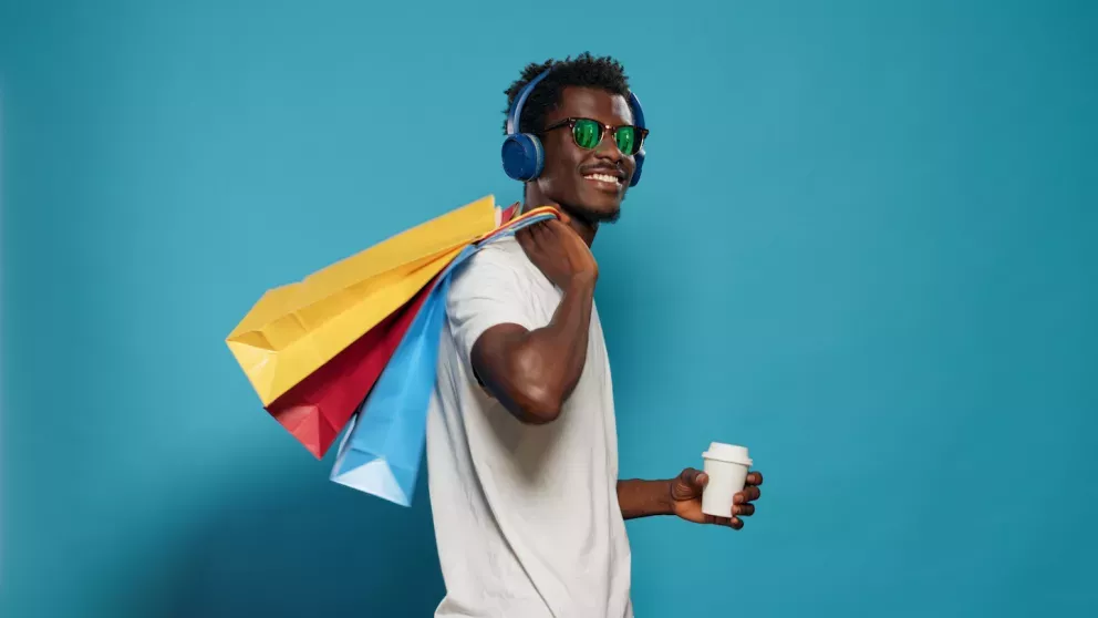 Man holding a coffee and shopping bags Man holding a coffee and shopping bags