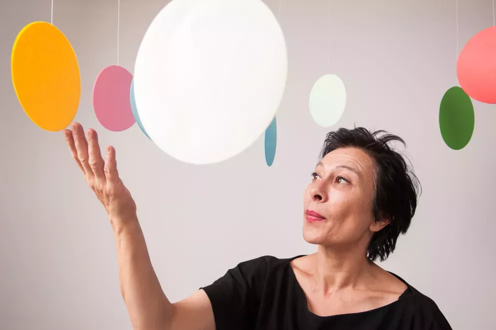 woman standing in the middle of hanging circle art pieces woman standing in the middle of hanging circle art pieces