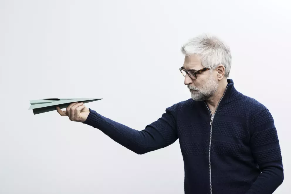 man looking at paper airplane man looking at paper airplane