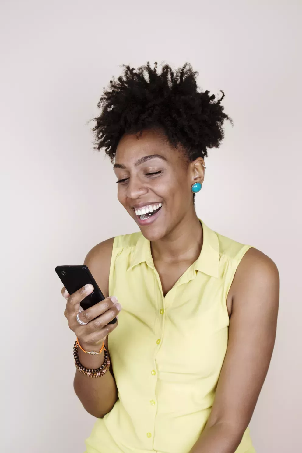 smiling woman looking at cell phone smiling woman looking at cell phone