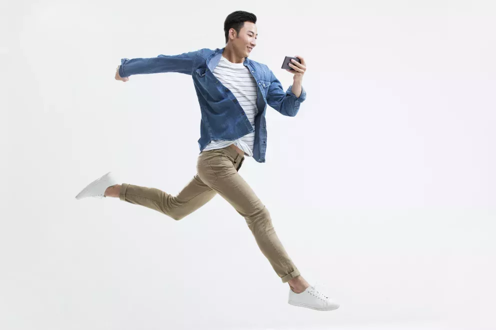 leaping man looking at cell phone leaping man looking at cell phone
