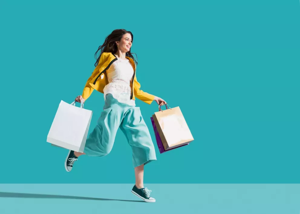 Woman jumping with shopping bags Woman jumping with shopping bags