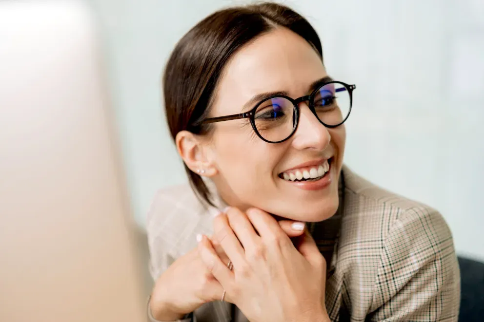 Woman at a computer smiling Woman at a computer smiling