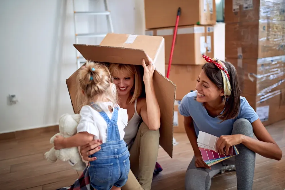 couple playing with toddler and moving box couple playing with toddler and moving box