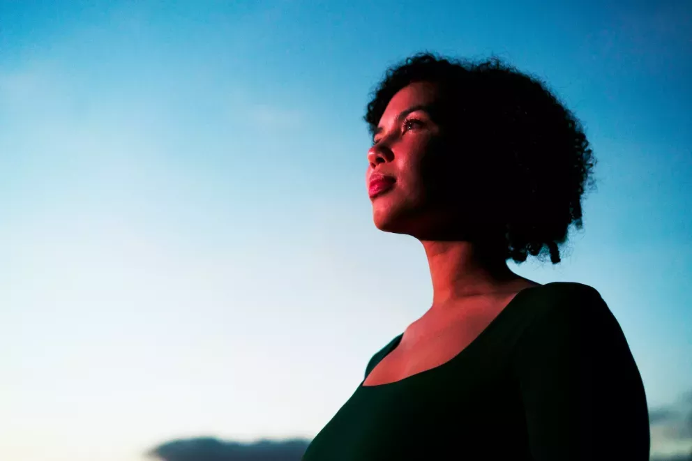 woman looking hopeful towards the sunrise woman looking hopeful towards the sunrise