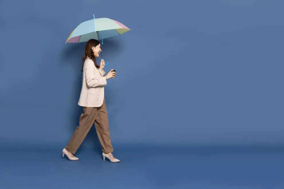 smiling business woman walking holding umbrella and coffee smiling business woman walking holding umbrella and coffee