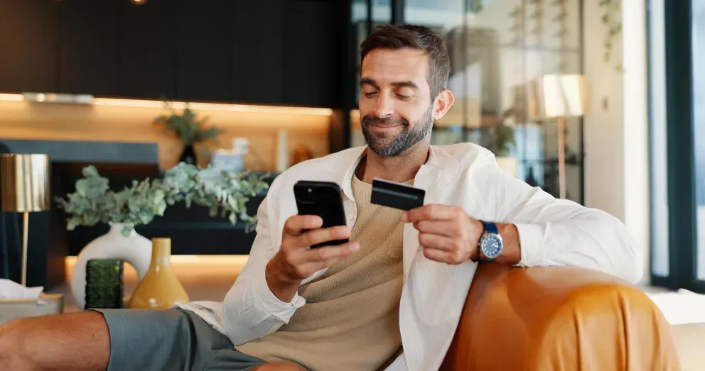 Person holding phone and credit card Person holding phone and credit card