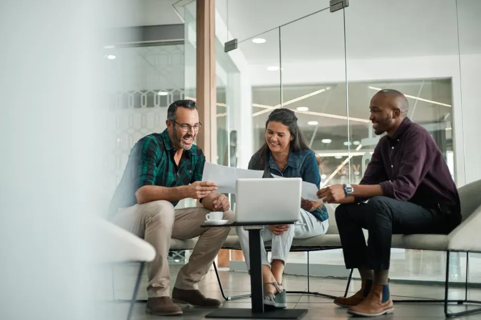 three people working together around a laptop three people working together around a laptop