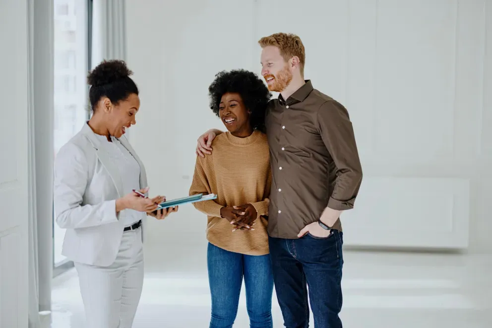 A couple speaking to a person with a clipboard A couple speaking to a person with a clipboard