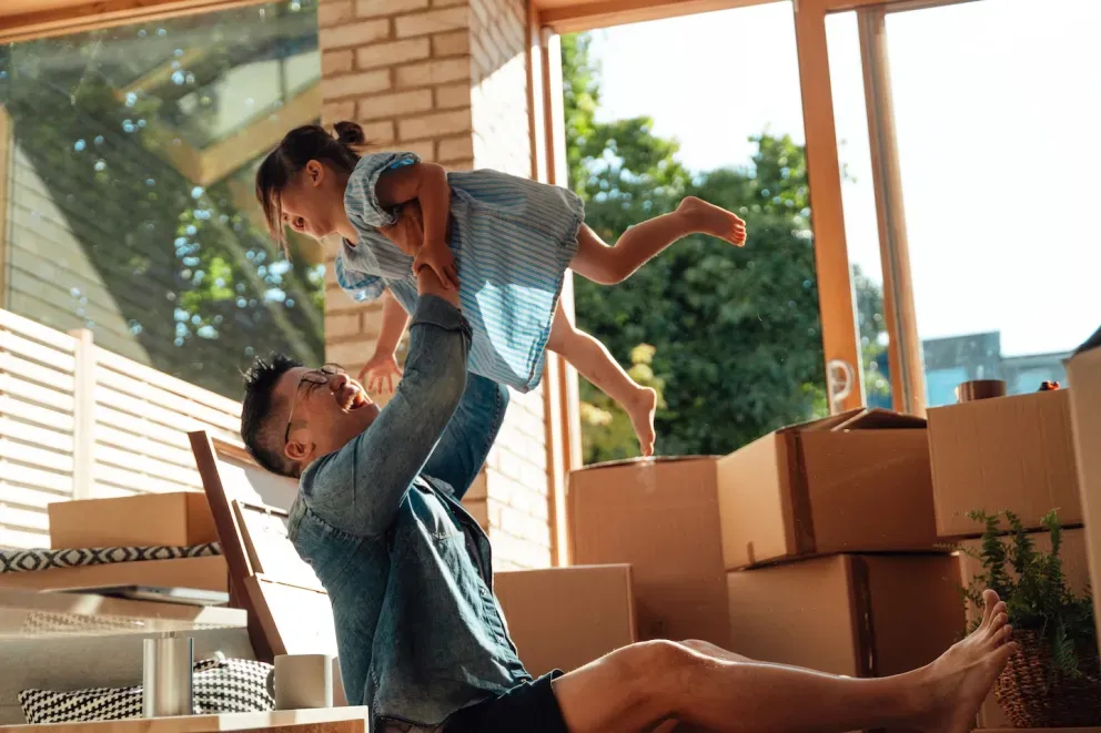 Father moving into new home and holding daughter up in the air. Father moving into new home and holding daughter up in the air.