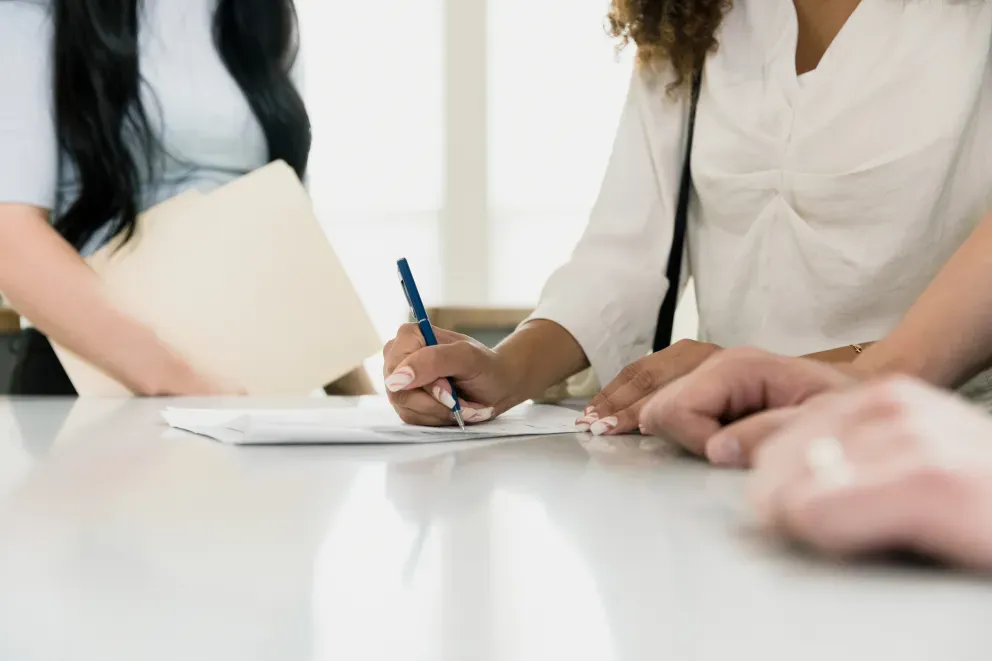 Women in meeting with pen and paper Women in meeting with pen and paper