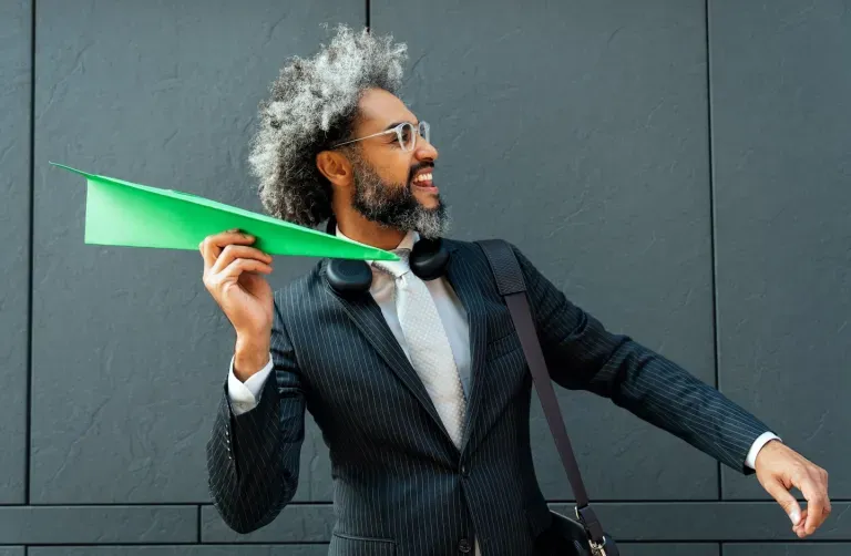 Person holding a paper plane Person holding a paper plane