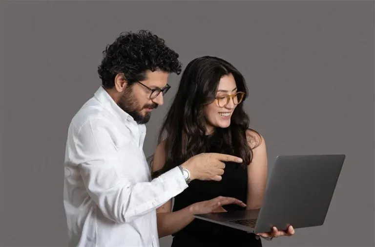 Two people staring at a laptop together Two people staring at a laptop together