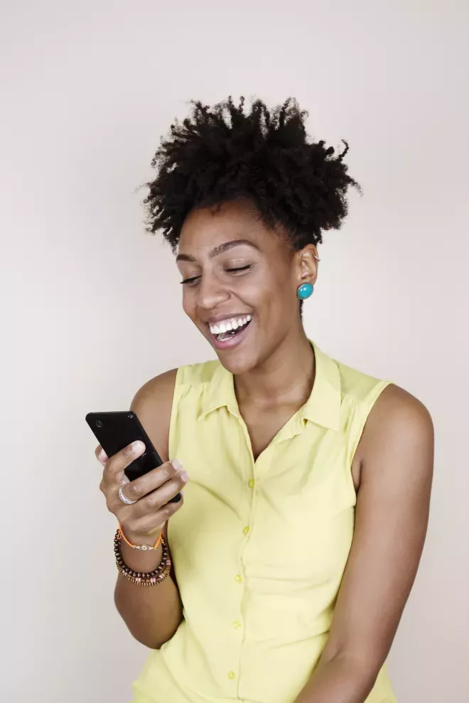 smiling woman looking at cell phone smiling woman looking at cell phone