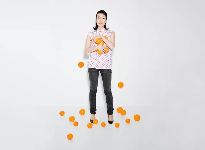 woman struggling to hold oranges woman struggling to hold oranges