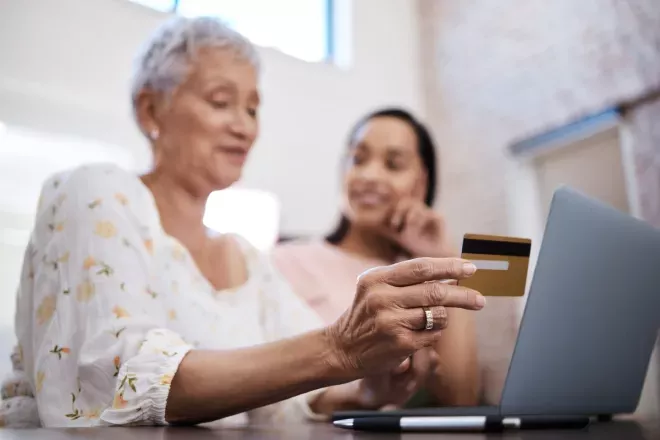 woman using a credit card at a computer woman using a credit card at a computer