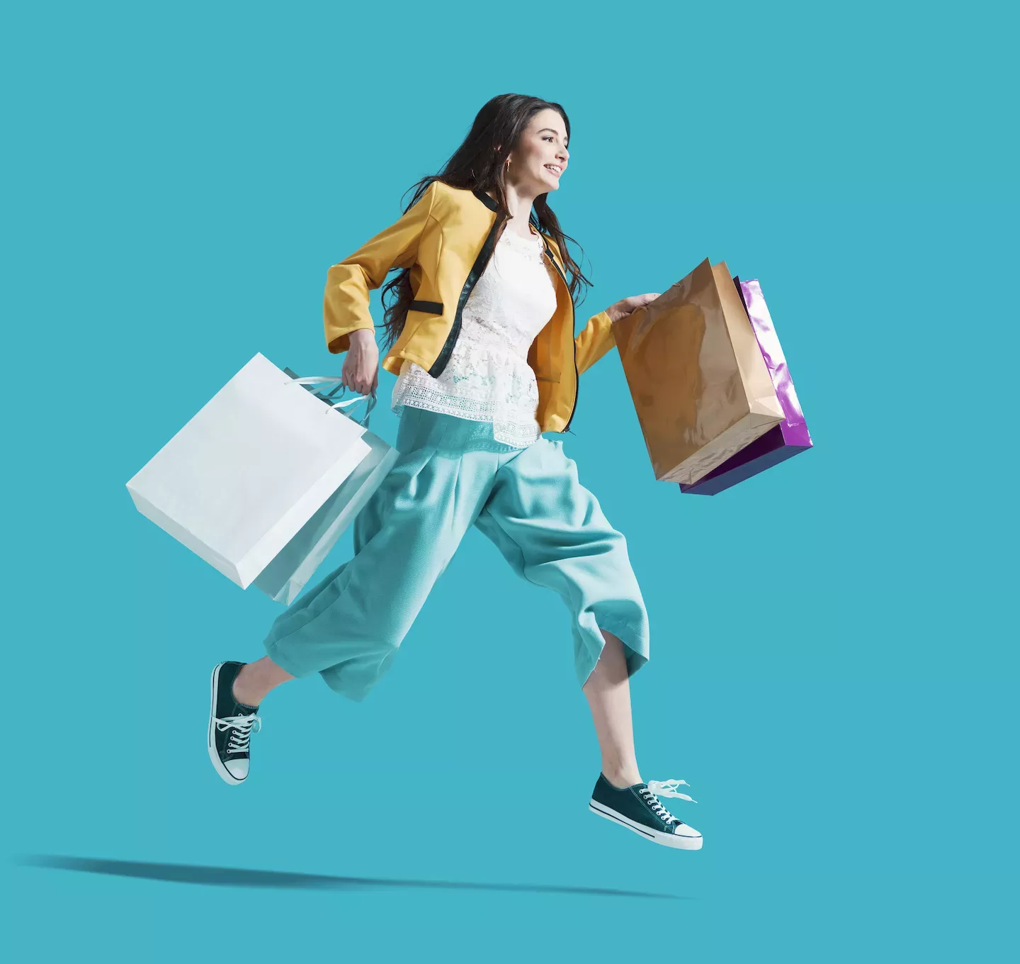 Woman jumping with shopping bags Woman jumping with shopping bags