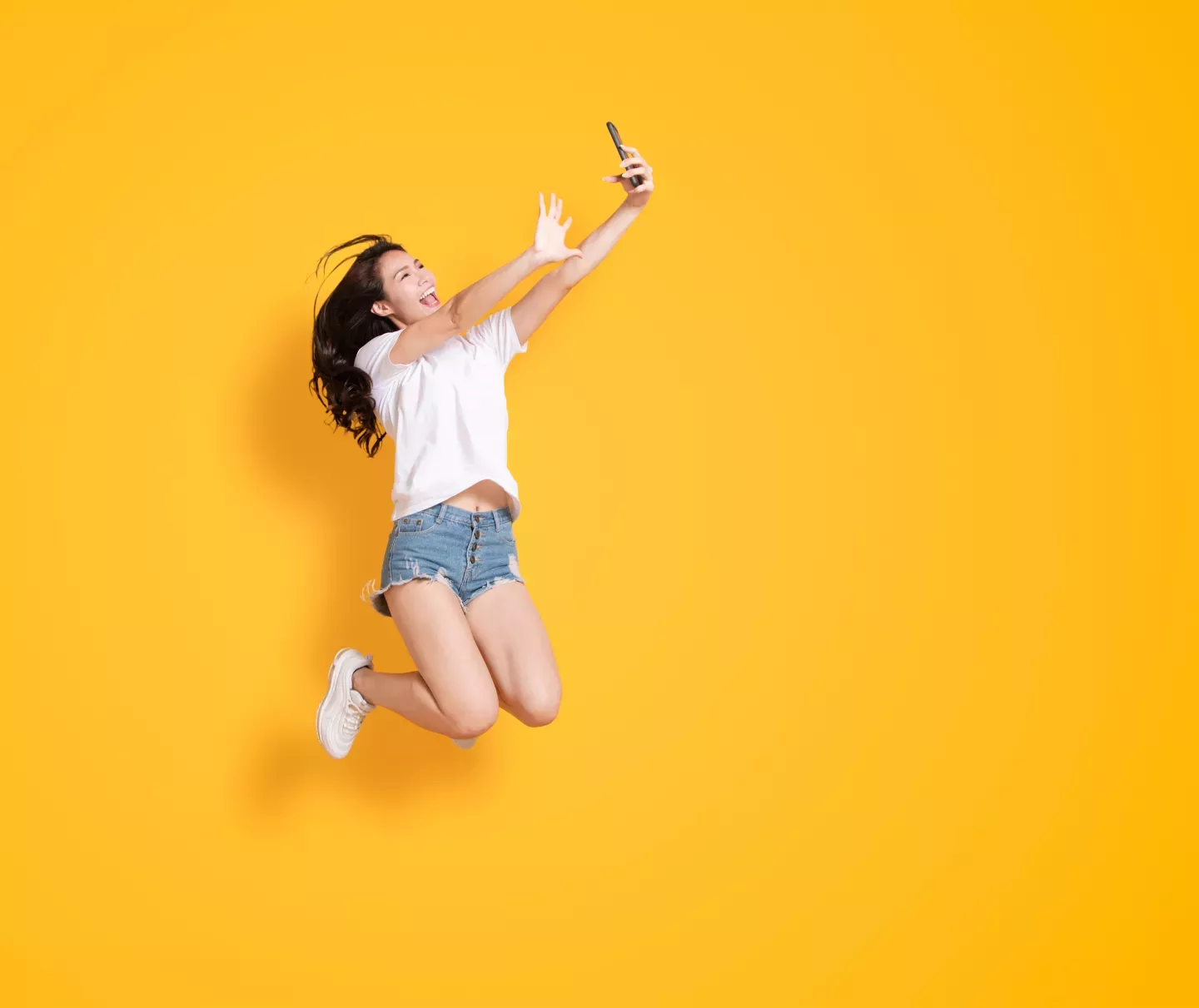 Woman jumping looking at a phone Woman jumping looking at a phone