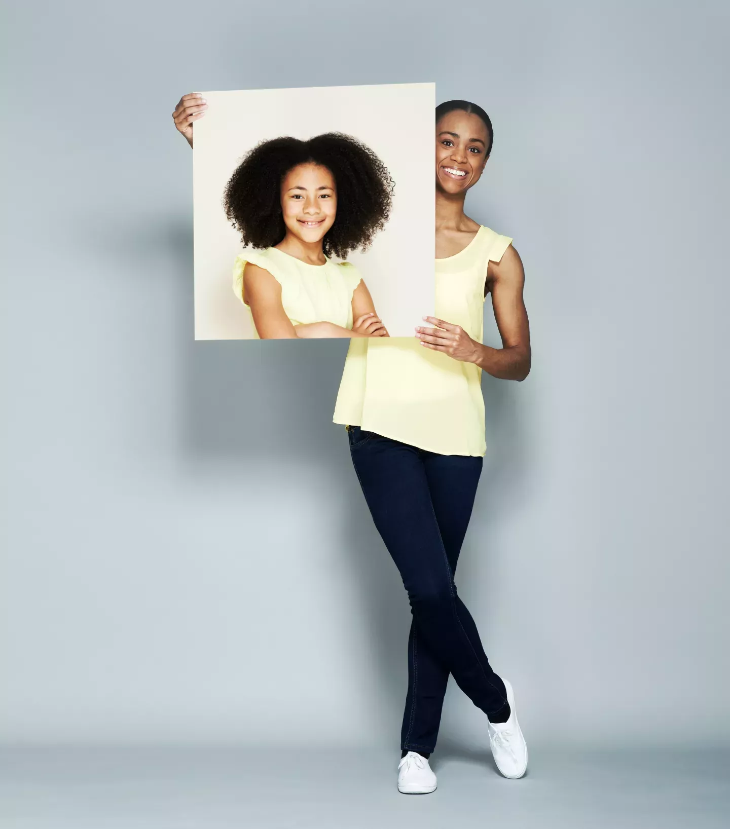 Woman holding a picture of herself as a child Woman holding a picture of herself as a child