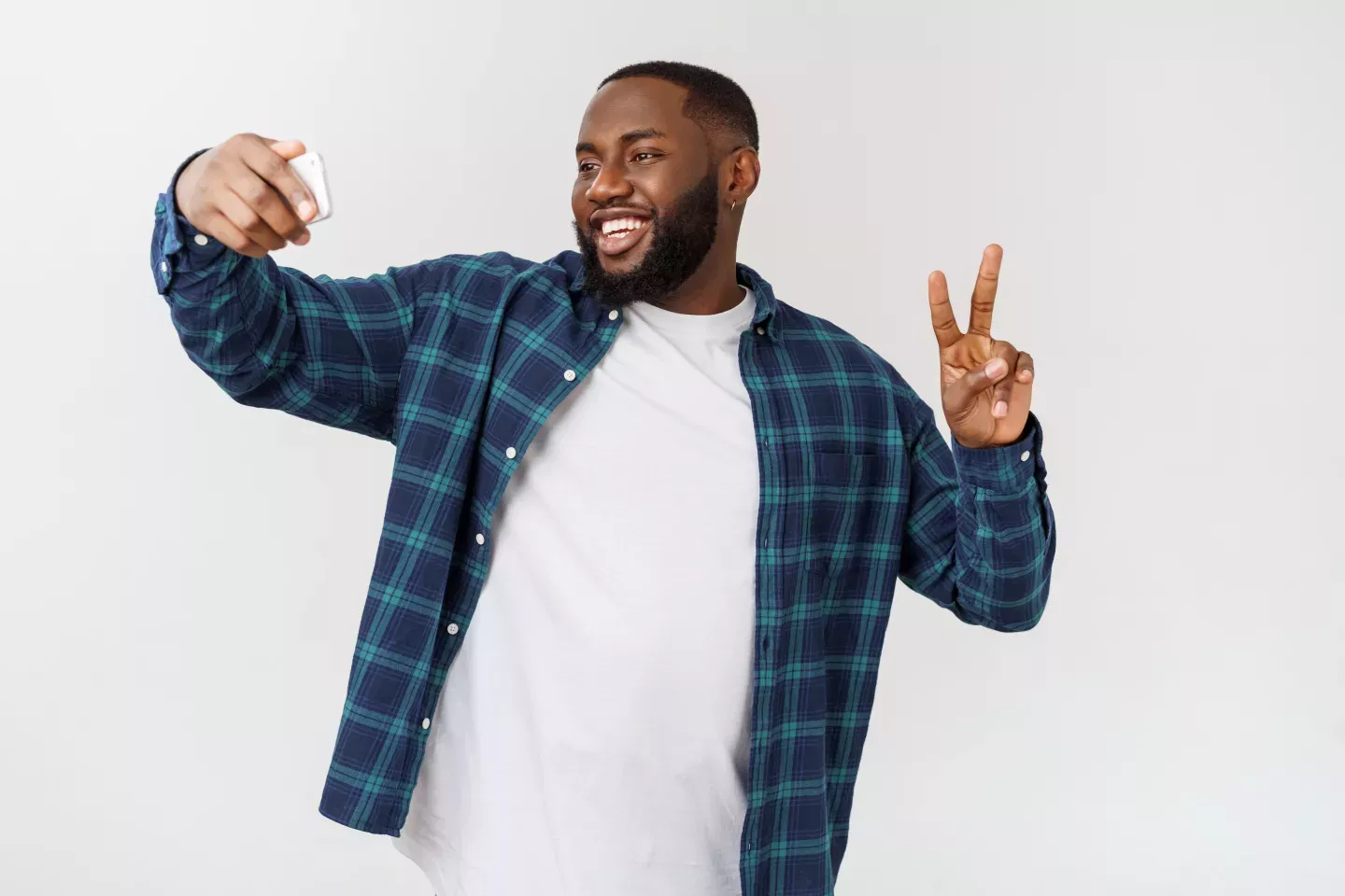 man taking selfie holding up hand to make a peace sign man taking selfie holding up hand to make a peace sign