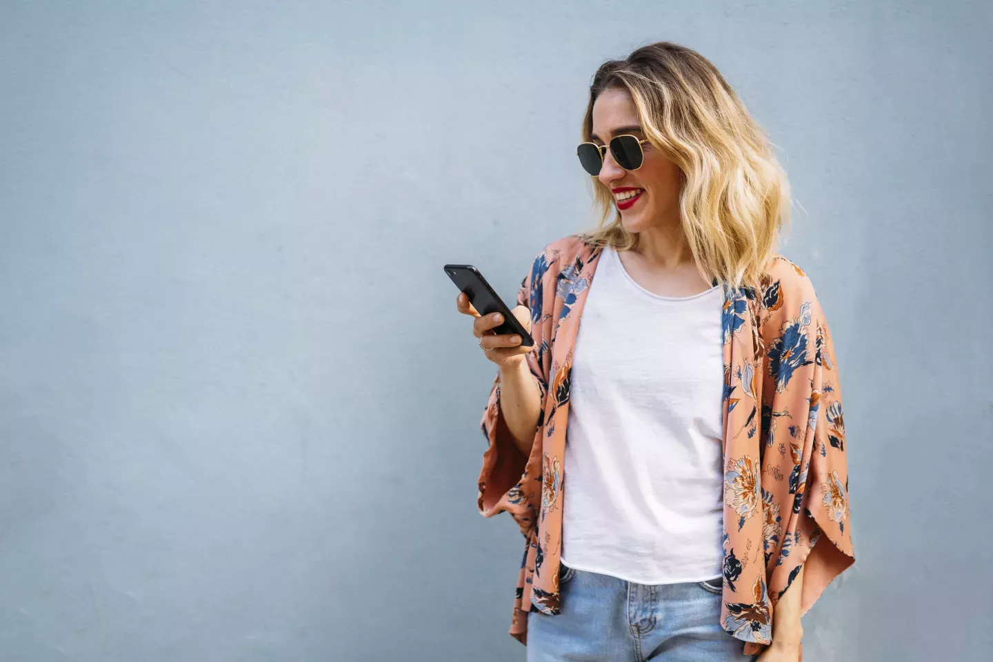 smiling woman looking at cell phone smiling woman looking at cell phone