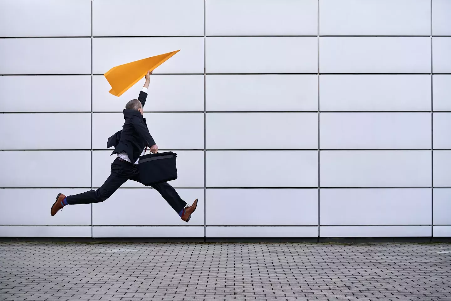 Man jumping with a paper airplane Man jumping with a paper airplane