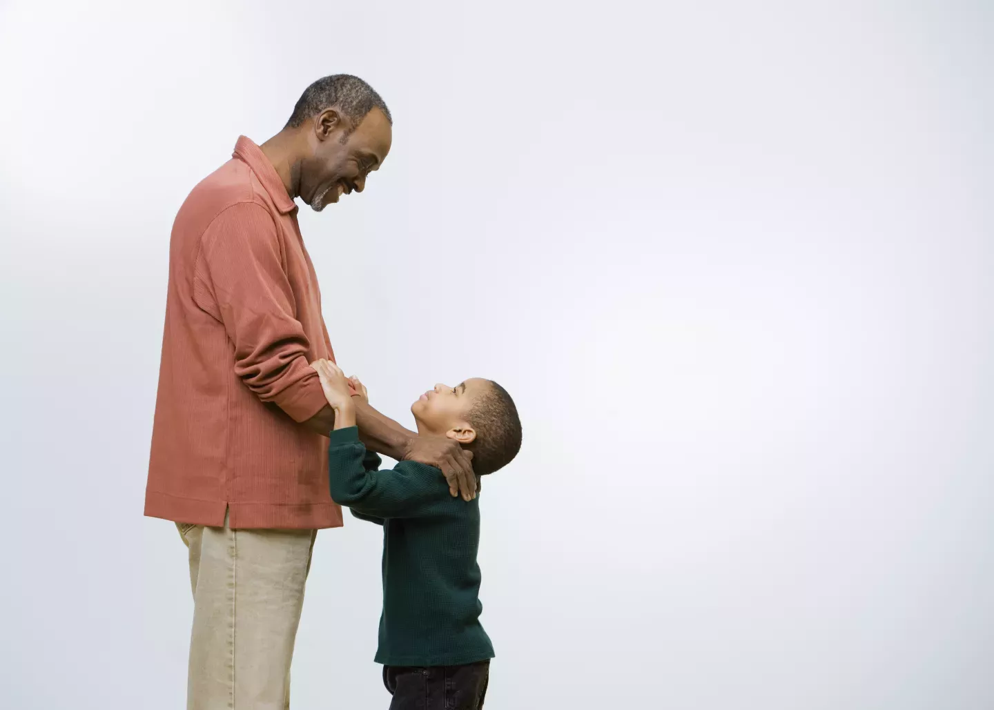 young son looking up at smiling father young son looking up at smiling father