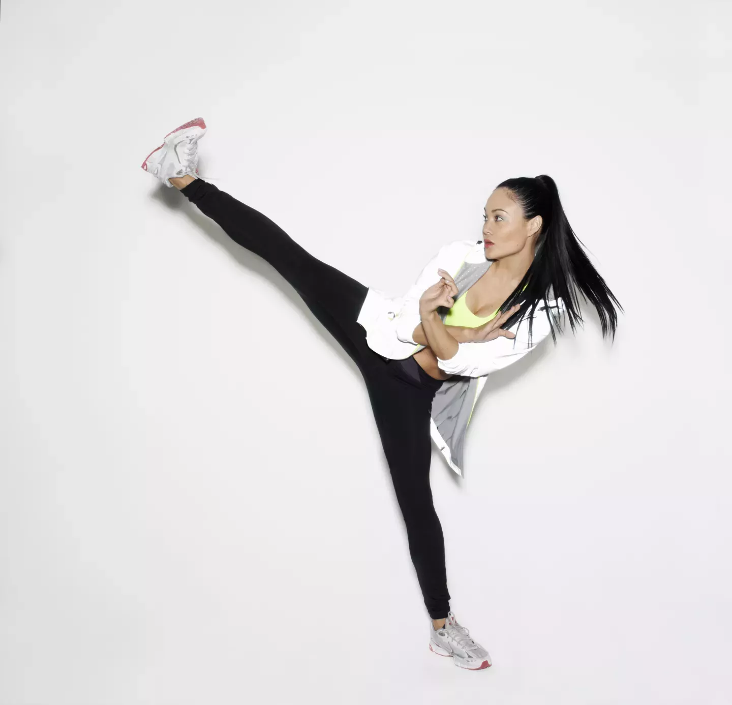 Determined athletic woman high kicking Determined athletic woman high kicking