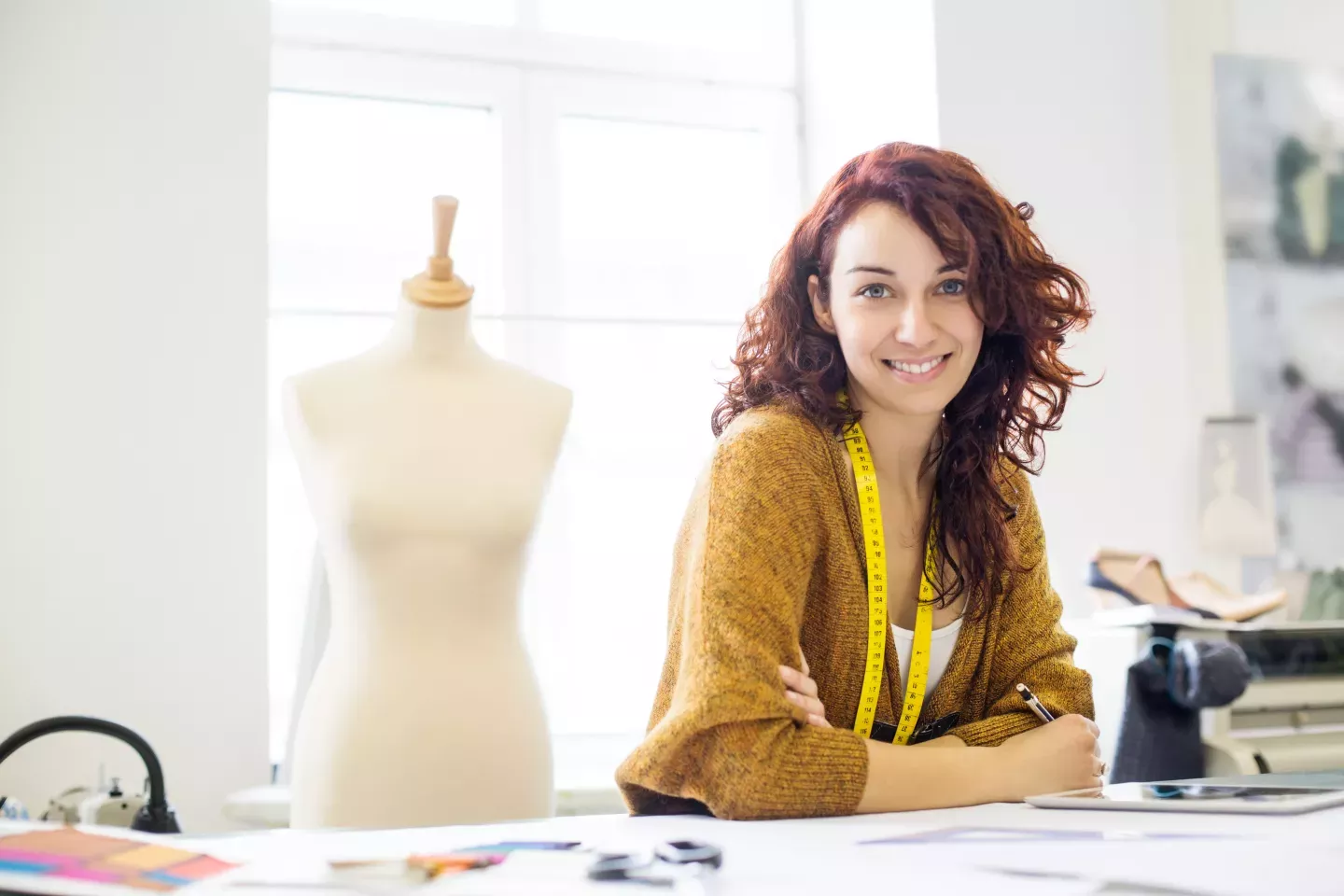 smiling seamstress leaning over workbench table smiling seamstress leaning over workbench table