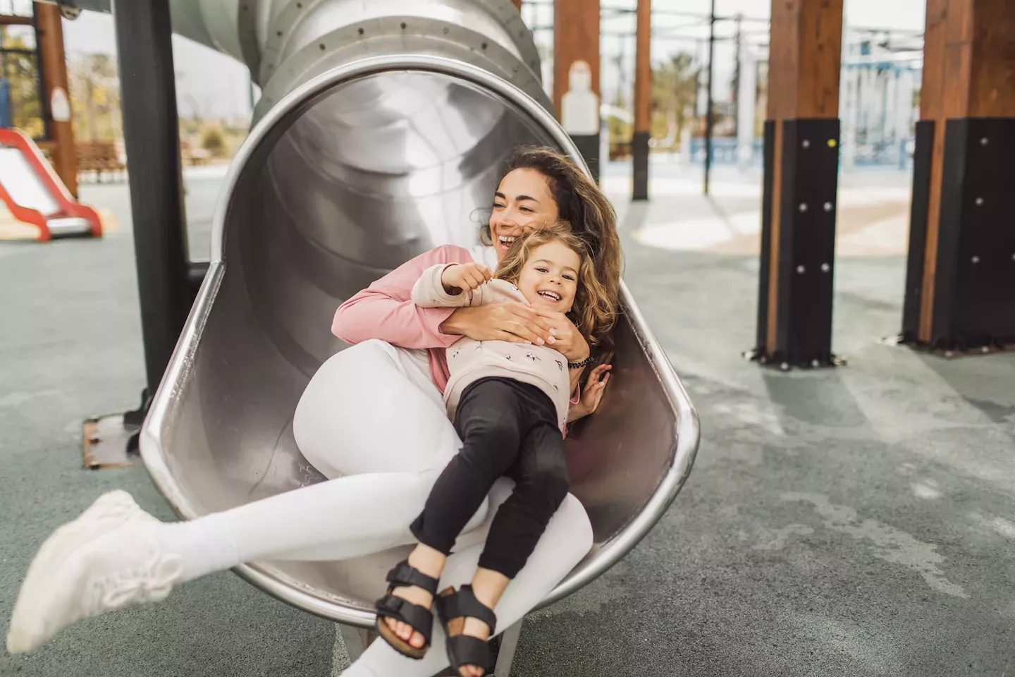 Mom and daughter going down a slide Mom and daughter going down a slide