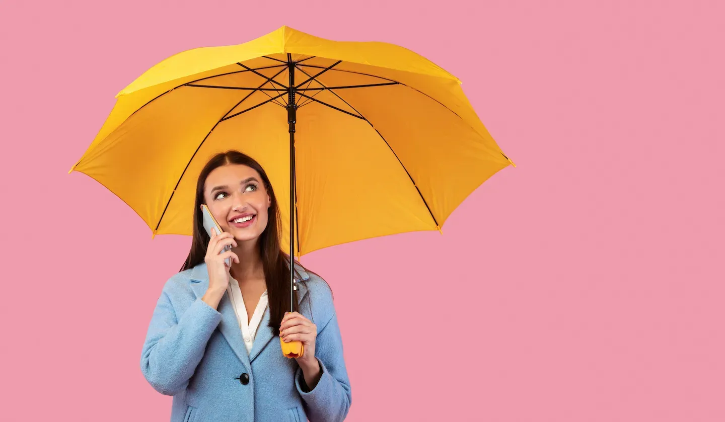 woman on cell phone holding unbrella woman on cell phone holding unbrella