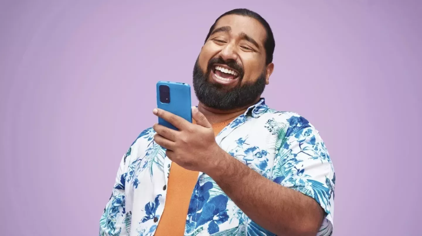 Man looking at a mobile phone and laughing Man looking at a mobile phone and laughing