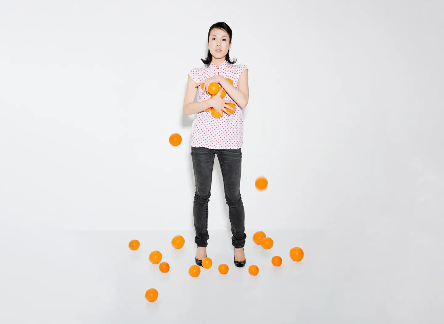 woman struggling to hold oranges woman struggling to hold oranges