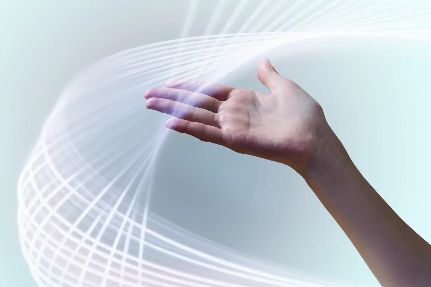 An outstretched hand with glowing white swirling light waves on a soft blue background. An outstretched hand with glowing white swirling light waves on a soft blue background.