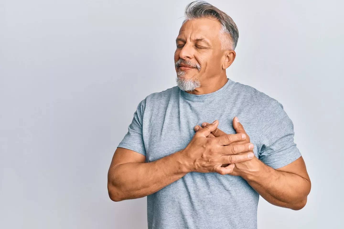 Man holding his hands over his heart Man holding his hands over his heart