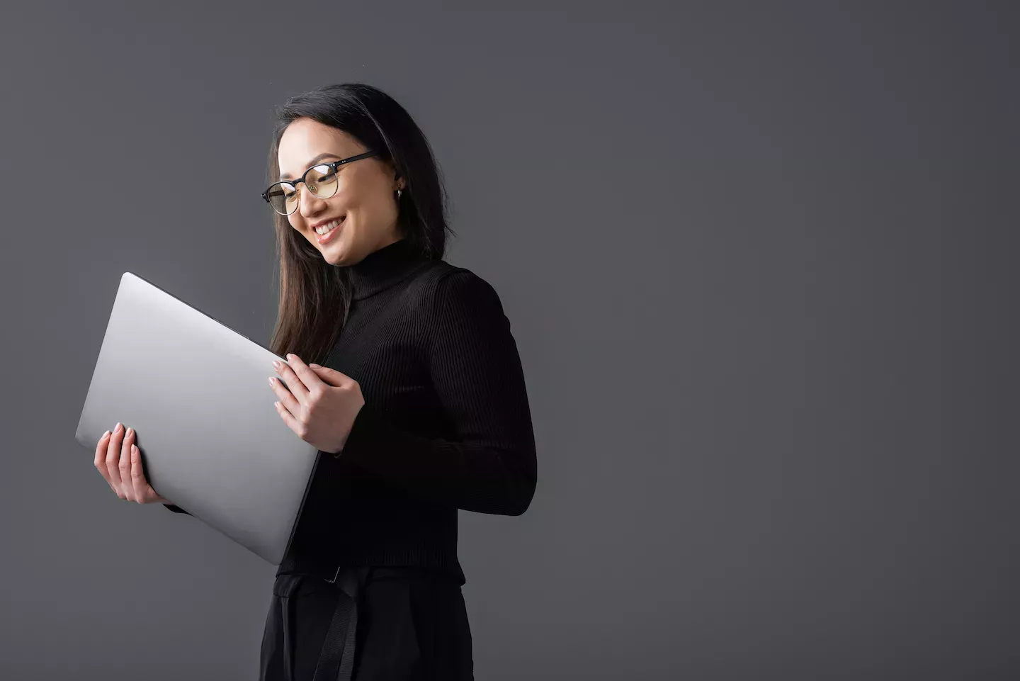 Woman smiling and holding a laptop Woman smiling and holding a laptop