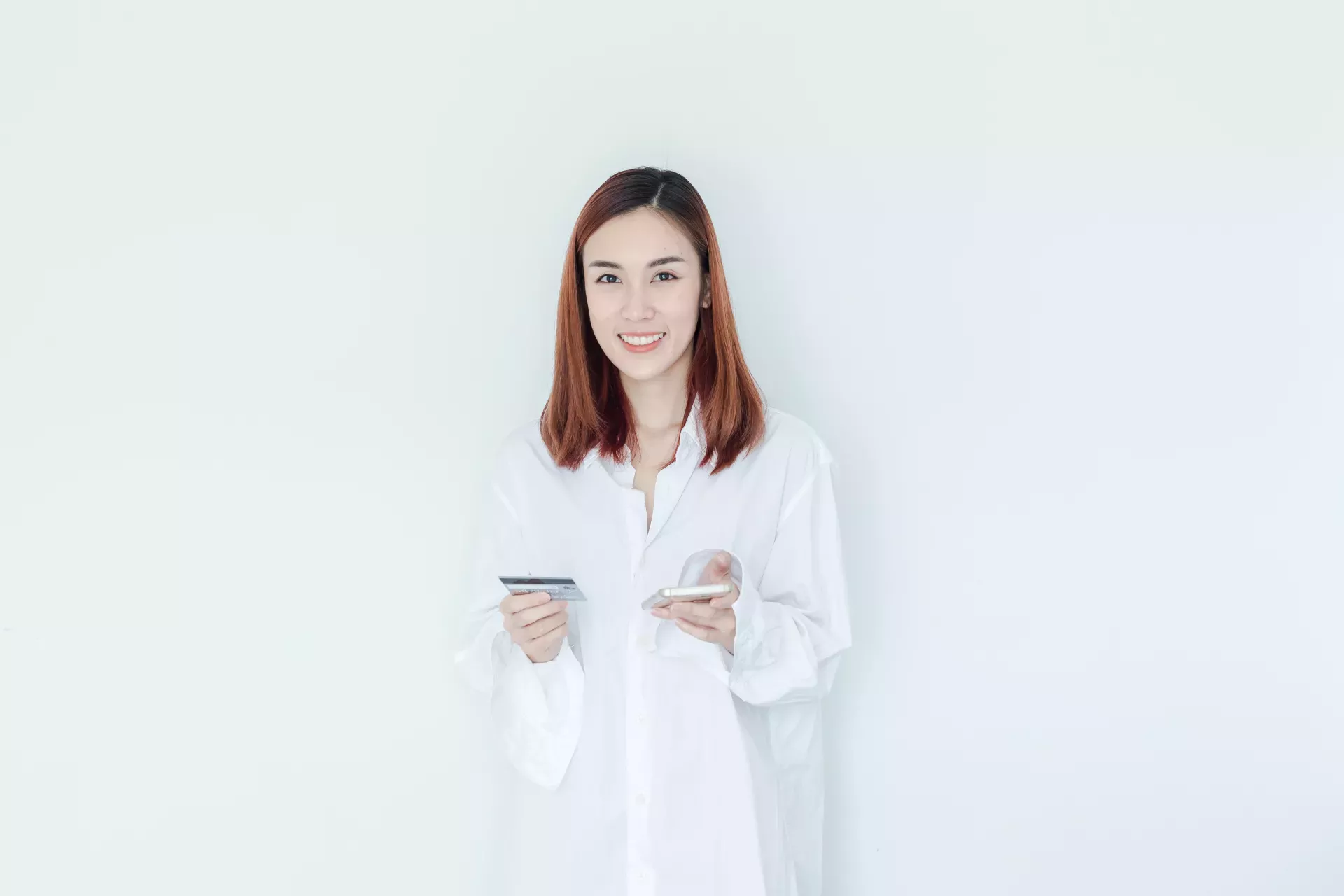 smiling woman holding cell phone and credit card smiling woman holding cell phone and credit card
