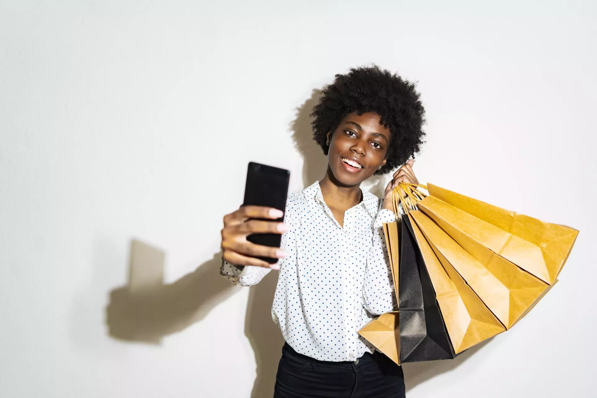 Woman holding shopping bags and taking selfie Woman holding shopping bags and taking selfie