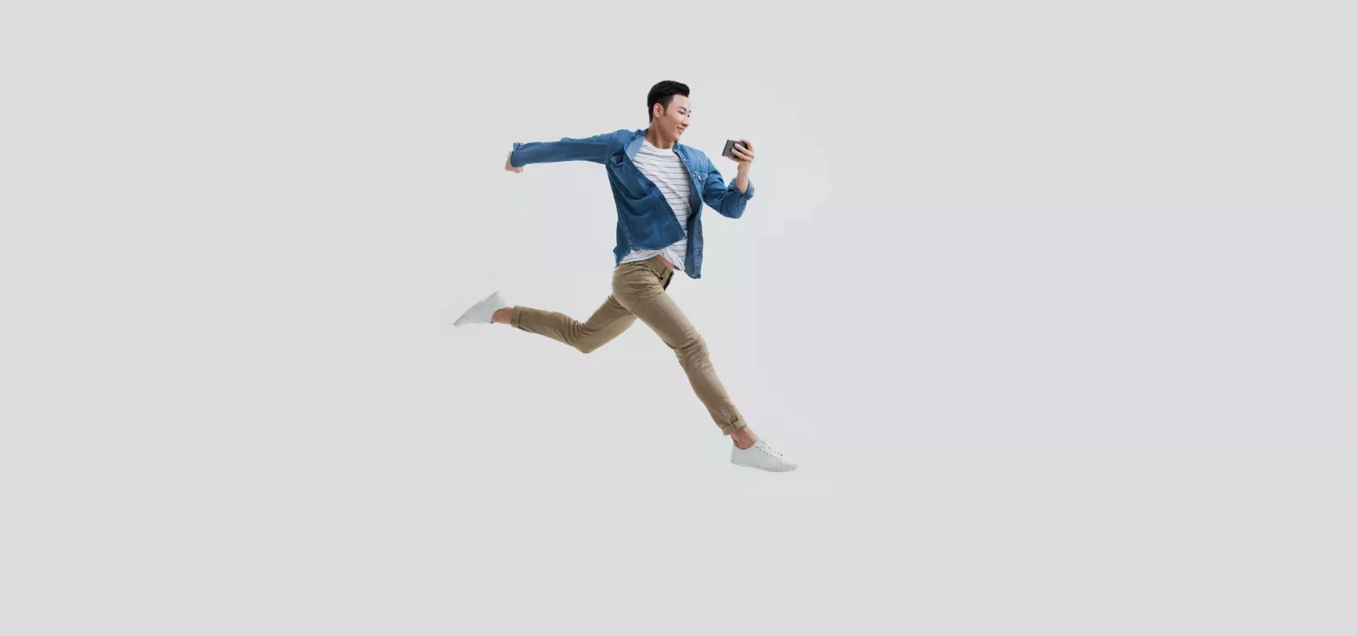 Man jumping looking at phone Man jumping looking at phone