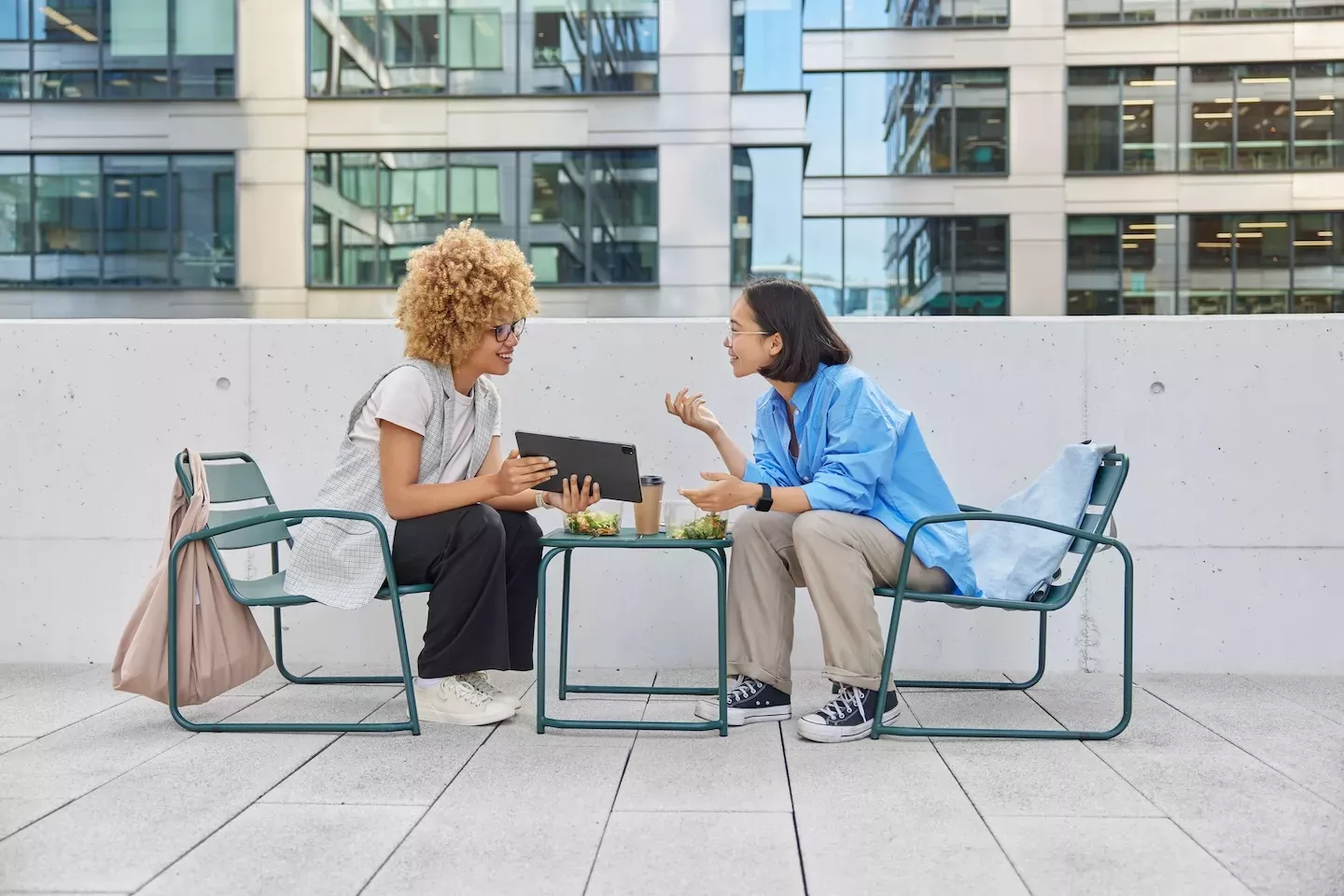 two people sitting and speaking outside two people sitting and speaking outside